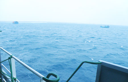 Hai thuyền đánh cá của ngư dân neo bên tàu để tránh sóng và phòng sự cố