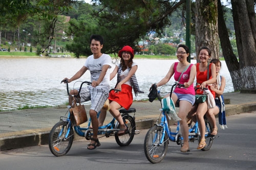 Nhóm du khách Tp Hồ Chí Minh dạo chơi vòng quanh Hồ Xuân Hương trên những chiếc xe đạp đôi. Ảnh Văn Báu