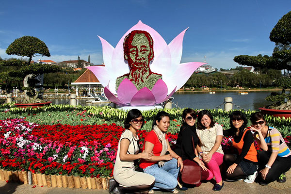 Du khách chụp hình lưu niệm trước tượng Bác Hồ làm bằng hoa