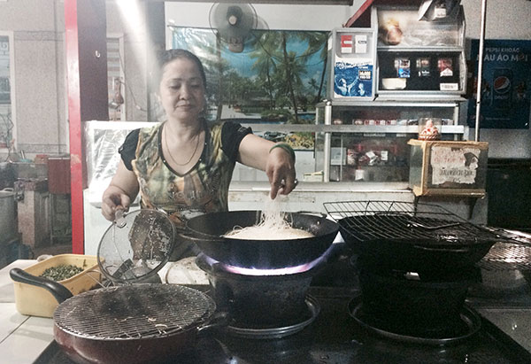 Bà Diễm Thúy đang chế biến món ăn “pizza hủ tíu” tại lò hủ tíu Sáu Hoài