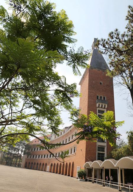 Trường CĐSP Đà Lạt với tháp chuông hướng về Hồ Xuân Hương, dáng cong mềm mại hài hòa với địa hình đồi thấp
