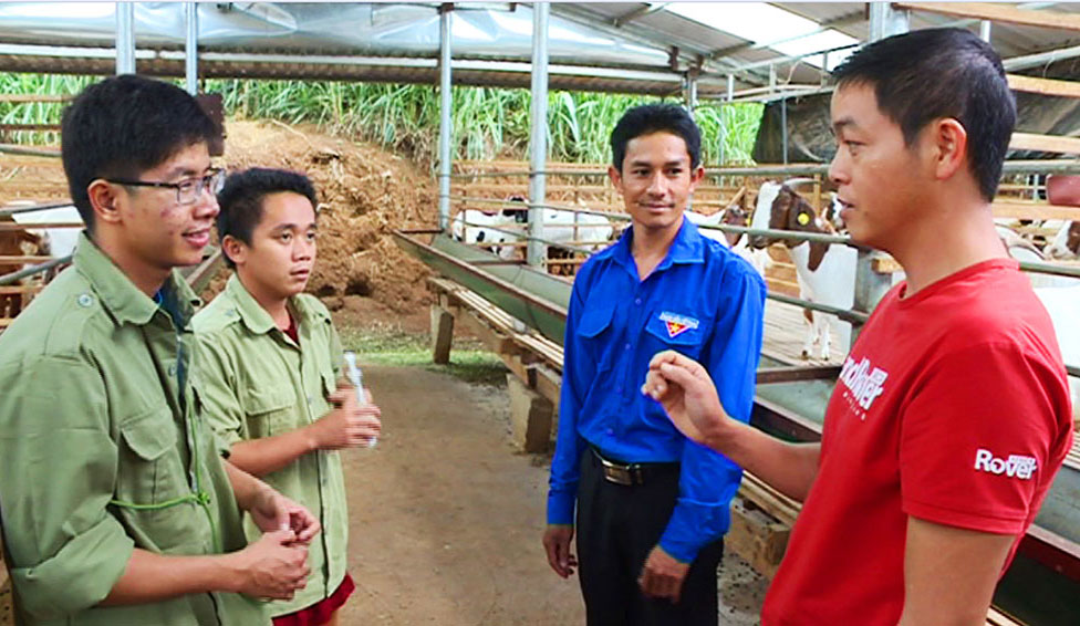 Anh Phạm Văn Hưng đang hướng dẫn kỹ thuật chăm sóc dê cho những lao động làm việc tại trang trại của mình