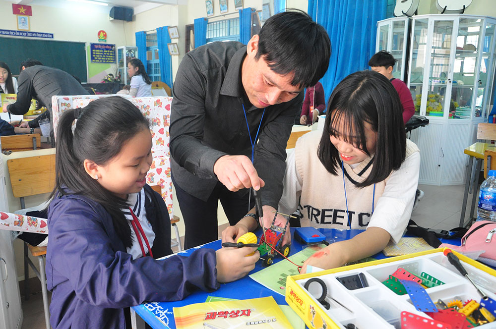 Thầy giáo Kim Sang Jun đang hướng dẫn học sinh lắp ráp xe tự hành. Ảnh: V.Trọng