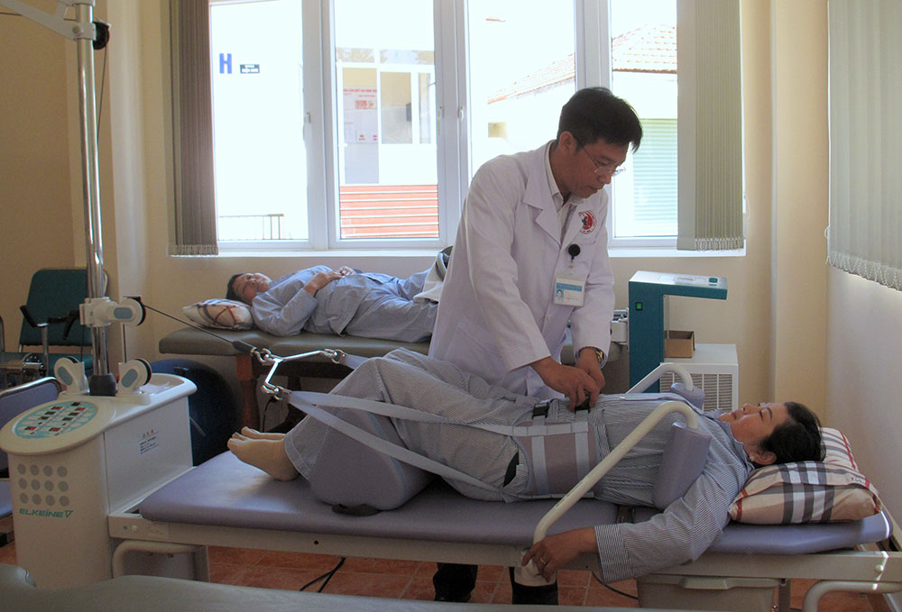 Bác sĩ Chuyên khoa I Vật lý trị liệu Võ Quang Tùng đang vận hành máy kéo dãn cột sống cho bệnh nhân.