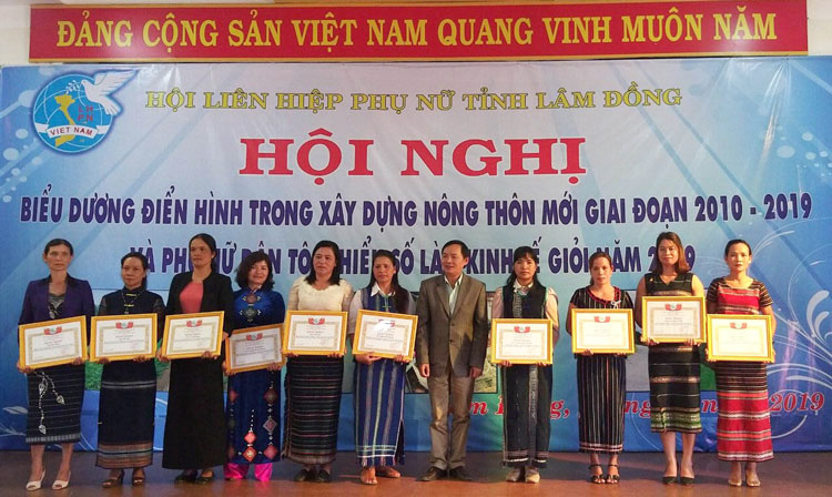 Chị MBon K’Nguyệt (bìa phải) nhận bằng khen của Hội LHPN tỉnh cho gương điển hình trong xây dựng NTM. Ảnh: H.My