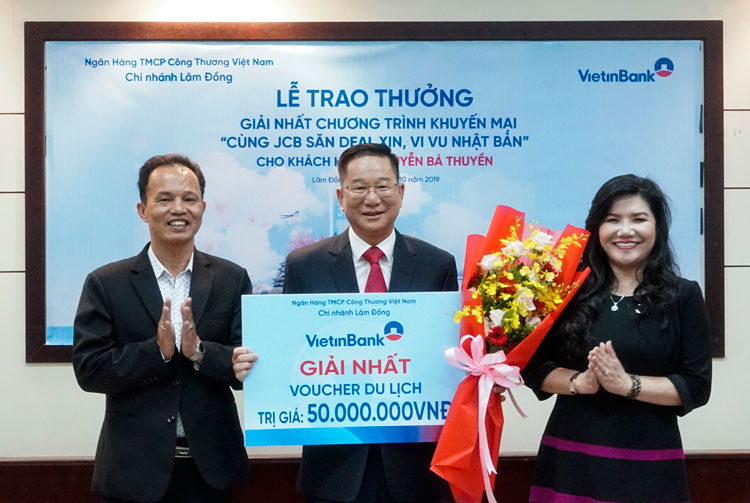 Ông Trương Quốc Thụ (Giám đốc Ngân hàng Nhà nước CN tỉnh Lâm Đồng – bên trái) và bà Phạm Thị Vạn Thanh (Giám đốc Vietinbank Lâm Đồng – bên phải) trao giải nhất cho ông Nguyễn Bá Thuyền (giữa)