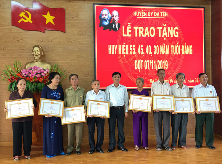 Đồng chí Nguyễn Mạnh Việt - Phó Bí thư Huyện ủy Đạ Tẻh trao tặng Huy hiệu Đảng cho các đảng viên.
