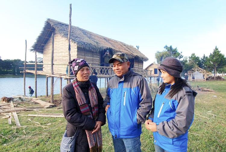 Nhà dân tộc học Đinh Thị Nga (trái) và cha con ông Nguyễn Hùng bên ngôi nhà dài vừa được dựng lại. Ảnh: Tiểu Vân