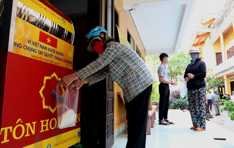 Người có hoàn cảnh khó khăn đến nhận gạo tại máy “ATM gạo” đặt ở chùa Phước Huệ. Ảnh: Khánh Phúc