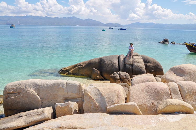 Một du khách trên tảng đá có hình dạng một con cá voi ven biển