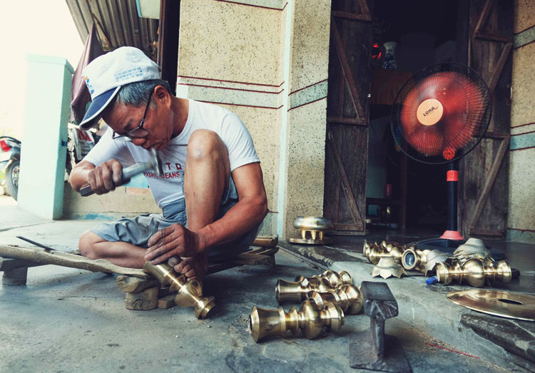 Nghệ nhân Trần Thiện dù đã 65 tuổi nhưng vẫn miệt mài hoàn thiện cho sản phẩm đồng của làng nghề truyền thống