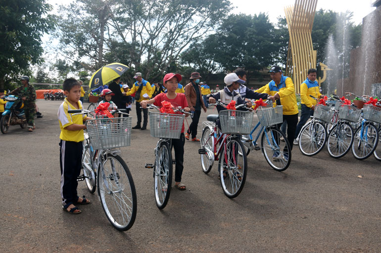 Các em học sinh phấn khởi nhận chiếc xe đạp