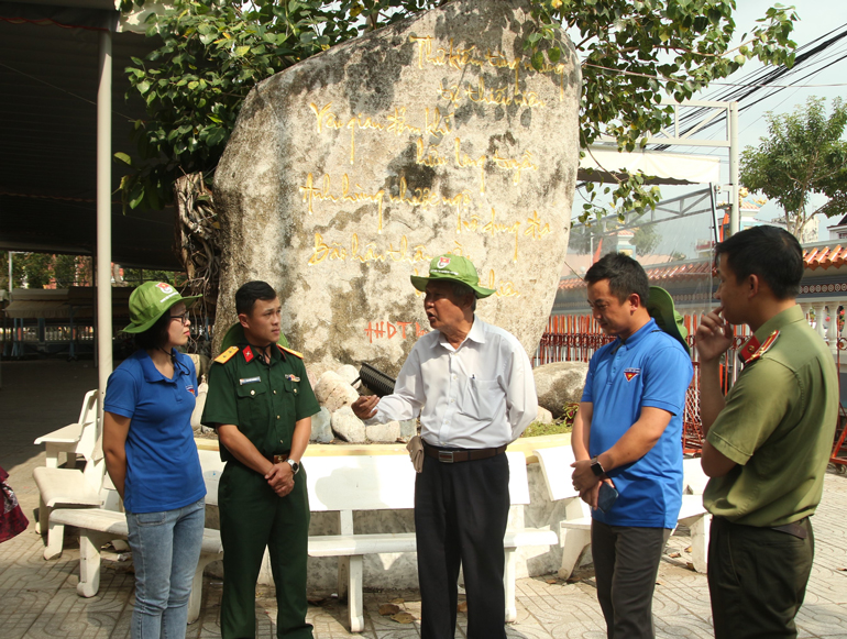 Ông Đặng Công Bình - Trưởng Ban bảo vệ di tích đền thờ hùng dân tộc Nguyễn Trung Trực (giữa) kể với khách tham quan về nguồn gốc của ngôi đền