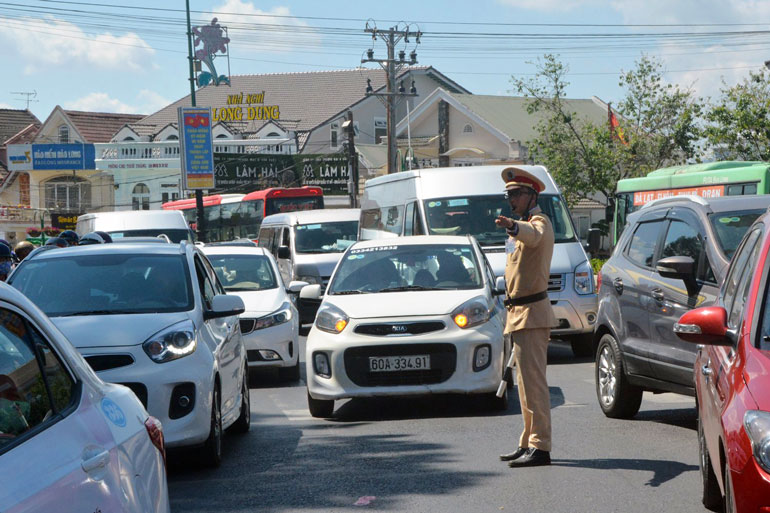 Cảnh sát giao thông giữa vòng vây xe cộ ở một giao lộ trung tâm thành phố Đà Lạt