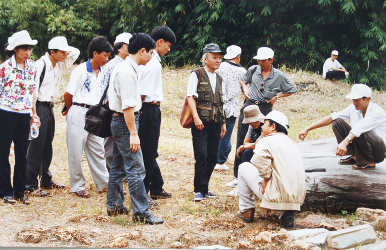 GS. Trần Quốc Vượng (người mặc áo ghi lê) cùng các nhà khoa học nghiên cứu tại hiện trường di tích Cát Tiên. Ảnh tư liệu Bảo tàng Lâm Đồng