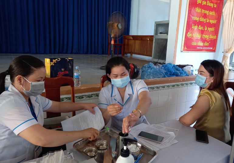 Cán bộ, nhân viên Trung tâm Y tế huyện Cát Tiên tổ chức tiêm vắc xin cho người dân tại điểm tiêm Trung tâm Bồi dưỡng Chính trị huyện