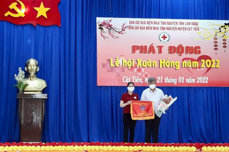 Lãnh đạo Hội Chữ thập đỏ tỉnh trao cờ lưu niệm và hoa cho lãnh đạo UBND huyện Cát Tiên.