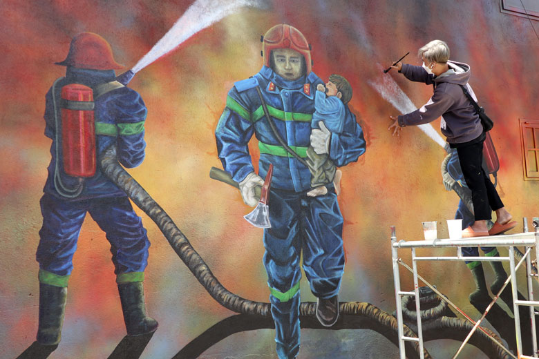 Họa sĩ trẻ Nguyễn Tuấn Đức đang hoàn thiện những nét vẽ cuối cùng trong bức tranh tưởng nhớ và tri ân 3 chiến sĩ phòng cháy chữa cháy hy sinh khi làm nhiệm vụ. 