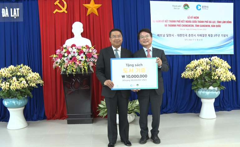 Đại diện TP Chuncheon trao tiền hỗ trợ mua sách cho học sinh xã Tà Nung