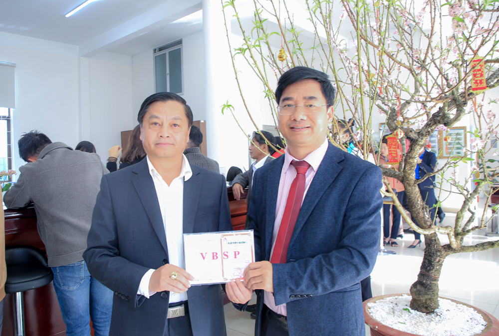 Ông Võ Văn Thanh (trái) - Giám đốc Ngân hàng Nhà nước chi nhánh tỉnh Lâm Đồng tham gia gởi tiền tiết kiệm