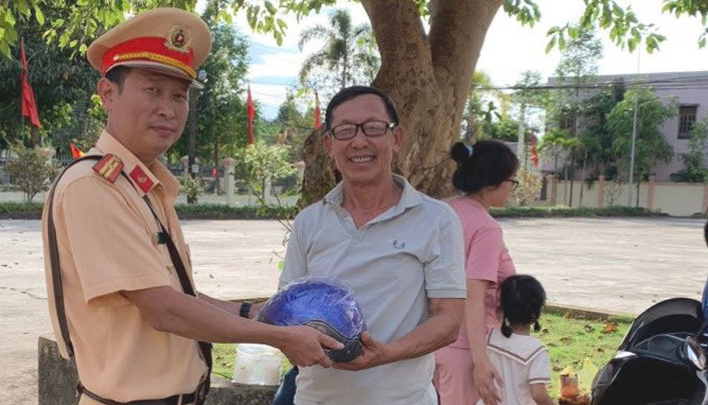 Công an huyện Đạ Huoai phát mũ bảo hiểm hỗ trợ người dân về quê đón tết an toàn