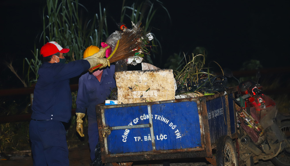 Công nhân vệ sinh môi trường tập trung thu gom rác tại chợ hoa xuân khu vực chợ mới Bảo Lộc trong đêm giao thừa Tết Nguyên đán Quý Mão