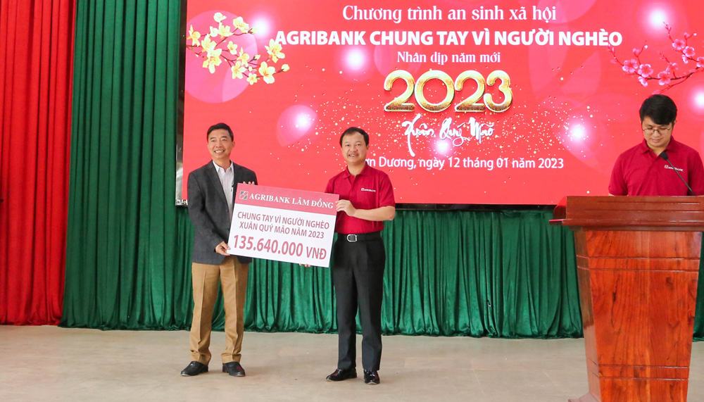 Ông Nguyễn Quang Tùng (giữa) trao biểu trưng tài trợ an sinh xã hội cho huyện Đơn Dương