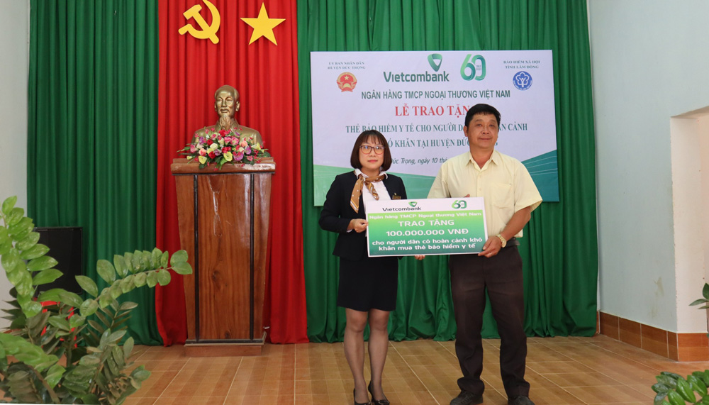 Lãnh đạo xã Tà Hine tiếp nhận bằng tượng trưng thẻ BHYT từ đại diện Vietcombank