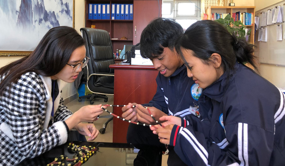 Hai học sinh nghiên cứu về sợi nhoong cùng với cô giáo hướng dẫn