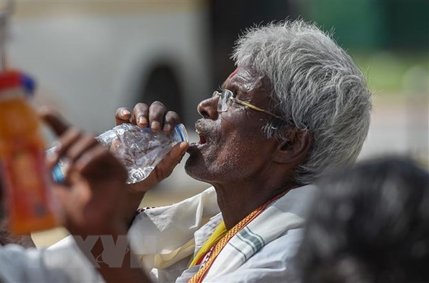 Người dân uống nước giải nhiệt trong thời tiết nắng nóng gay gắt tại New Delhi, Ấn Độ, ngày 23/5/2023