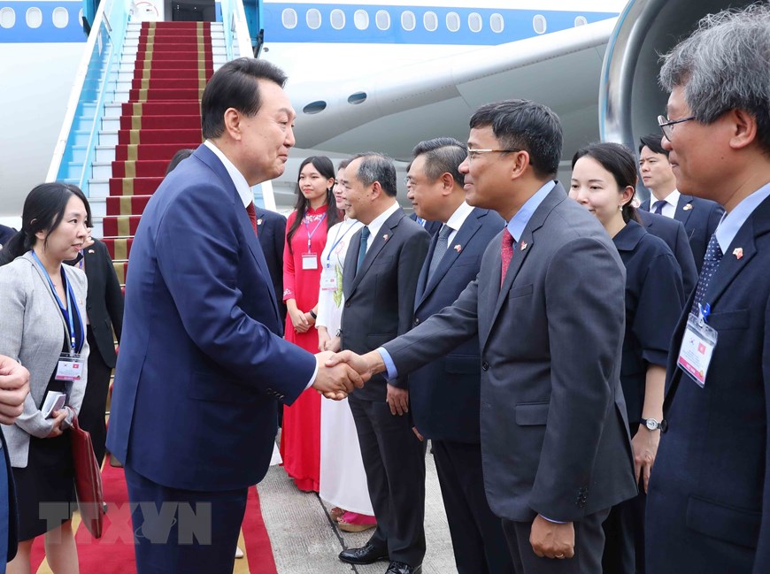 Thứ trưởng Ngoại giao Nguyễn Minh Vũ đón Tổng thống Hàn Quốc Yoon Suk Yeol và Phu nhân tại sân bay quốc tế Nội Bài. (Ảnh: An Đăng/TTXVN)