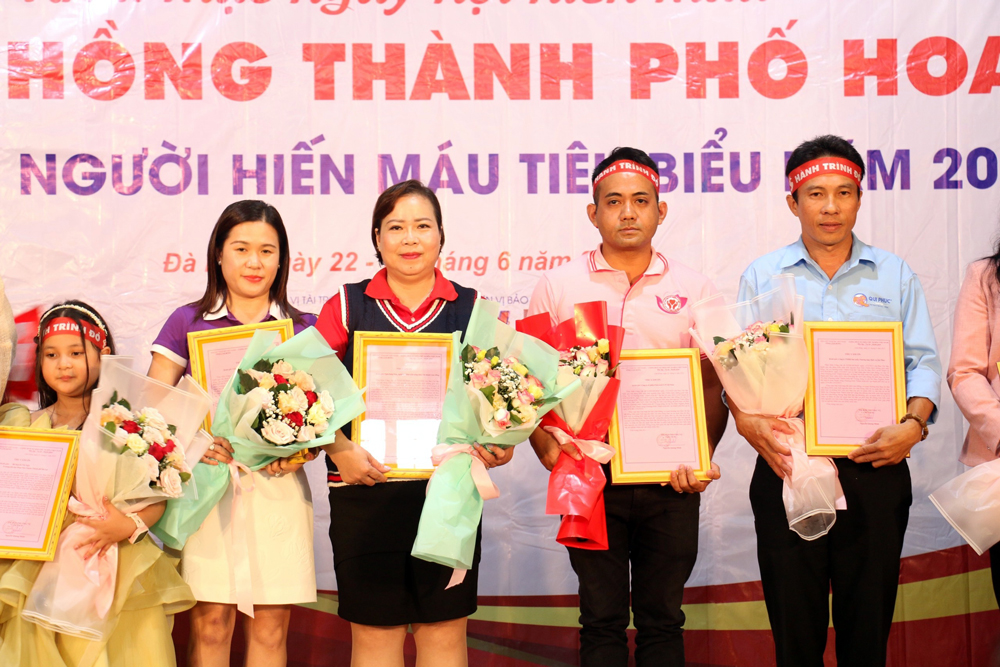 Ông Nguyễn Quốc Khang -Phó tổng Giám đốc nhân sự Công ty cổ phần chăn nuôi C.P Việt Nam (thứ tư từ trái sang) nhận thư cảm ơn và hoa từ Ban tổ chức Hành trình đỏ tại Lâm Đồng