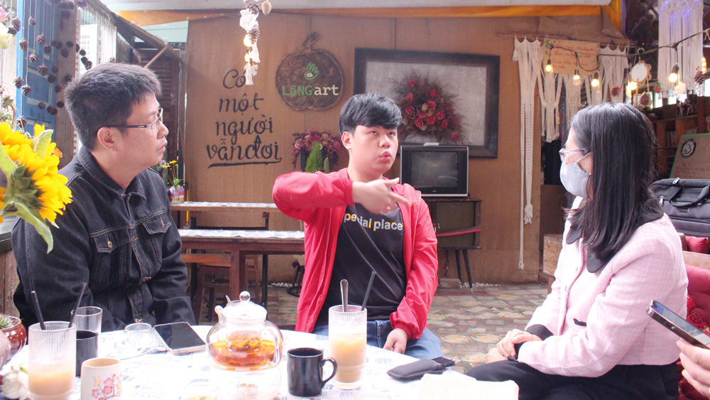 Nhân viên của Lặng Art Nguyễn Lương Quang (giữa) đang trao đổi cùng khách