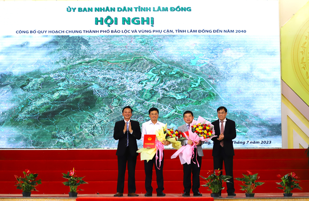 Đồng chí Võ Ngọc Hiệp – Phó Chủ tịch UBND tỉnh Lâm Đồng (bìa phải) trao quyết định phê duyệt quy hoạch chung cho lãnh đạo TP Bảo Lộc và huyện Bảo Lâm