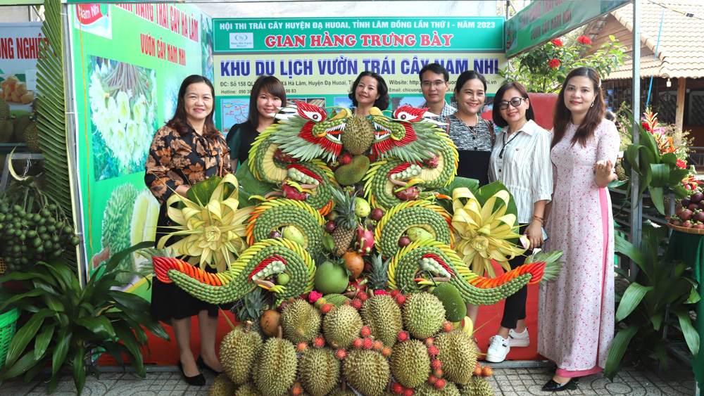 Du khách chụp hình lưu niệm bên tác phẩm trái cây Song Long hội tụ được trưng bày tại Hội thi trái cây huyện Đạ Huoai