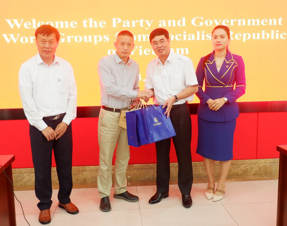 Đồng chí Trần Đình Văn và đại diện doanh nghiệp tỉnh Lâm Đồng trao quà lưu niệm là các mặt hàng đặc sản địa phương đến lãnh đạo Học viện Khoa học Nông nghiệp Quảng Đông