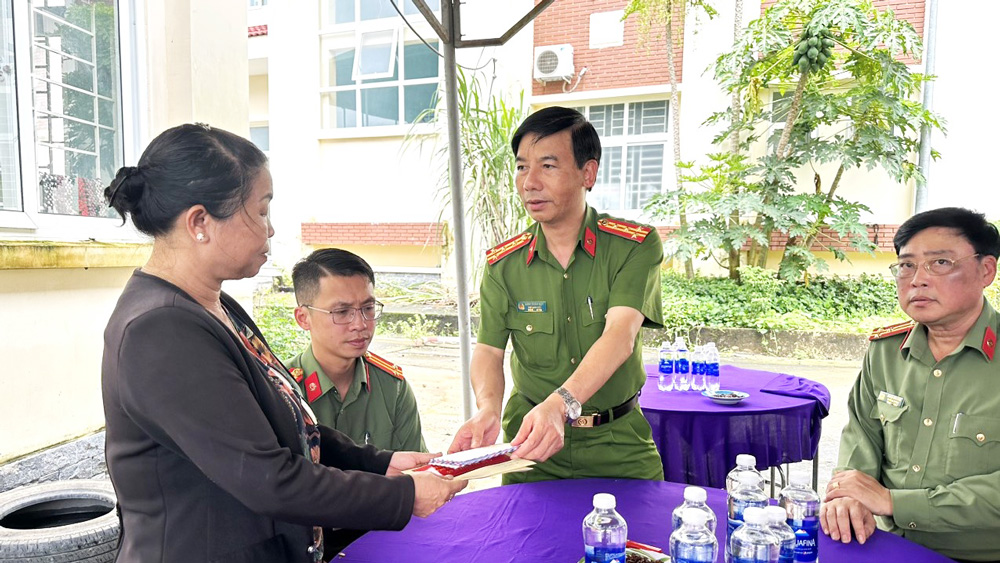 Đại tá Đinh Xuân Huy - Phó Giám đốc Công an tỉnh Lâm Đồng trao hỗ trợ 50 triệu đồng cho gia đình anh Phạm Ngọc Anh. Ảnh: Lê Tiến