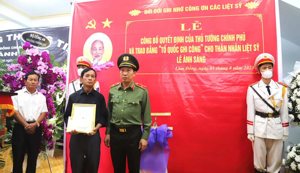 Thiếu tướng Lê Văn Tuyến trao Quyết định của Bộ trưởng Bộ công an về thăng cấp bậc hàm vượt bậc từ Thượng úy lên Đại úy  cho thân nhân gia đình liệt sĩ Lê Ánh Sáng