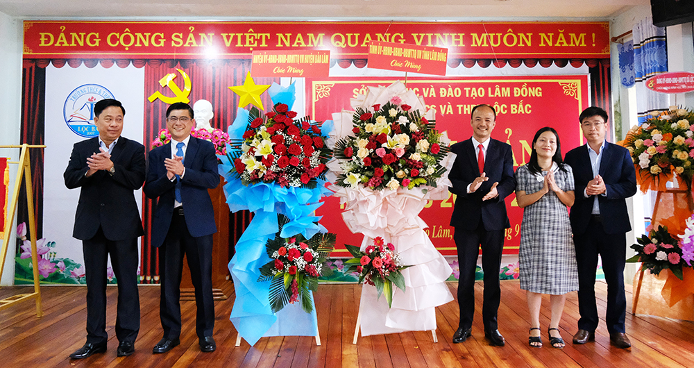 Đồng chí Nguyễn Khắc Bình - Phó Chủ tịch HĐND tỉnh và ông Phan Anh Tuấn – Phó Chủ tịch UBND huyện tặng hoa chúc mừng thầy và trò Trường THCS-THPT Lộc Bắc