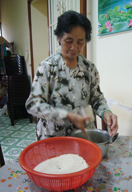 Bà Bạc Thị Thim đong lúa nếp chuẩn bị cho bữa ăn.