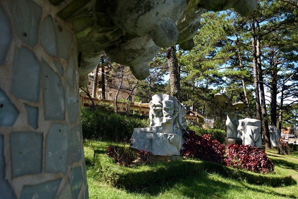 Hơn 20 tác phẩm điêu khắc bày dưới tán thông và cỏ hoa trong mảnh vườn hình tam giác.