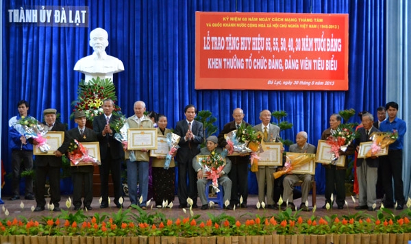Chủ tịch UBND tỉnh trao huy hiệu và chụp hình lưu niệm với các đảng viên lão thành. Ảnh Văn Báu
