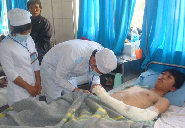 Bác sĩ khoa ngoại đang chăm sóc vết thương cho nạn nhân Tống Phước Hậu