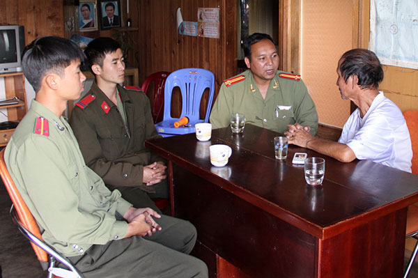 Trung tá Sing Công Minh (thứ 3 từ trái qua) thăm hỏi người có uy tín ở thị trấn Lạc Dương