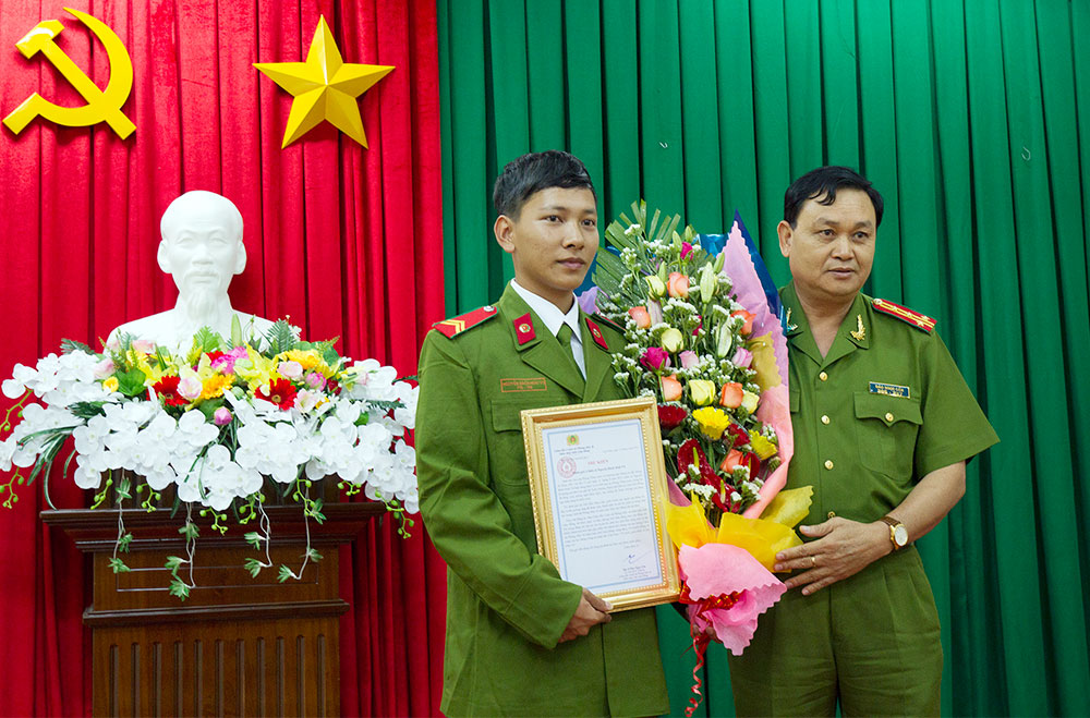 Đại tá Đào Ngọc Cần - Giám đốc Cảnh sát PCCC tỉnh Lâm Đồng trao thư khen kèm tiền thưởng cho chiến sỹ Vũ 
