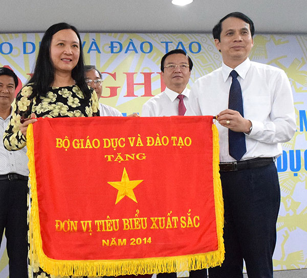 Bà Đàm Thị Kinh nhận Cờ thi đua của Bộ GD&ĐT trao cho Sở GD&ĐT Lâm Đồng vì có thành tích hoàn thành xuất sắc nhiệm vụ năm học 2014 - 2015