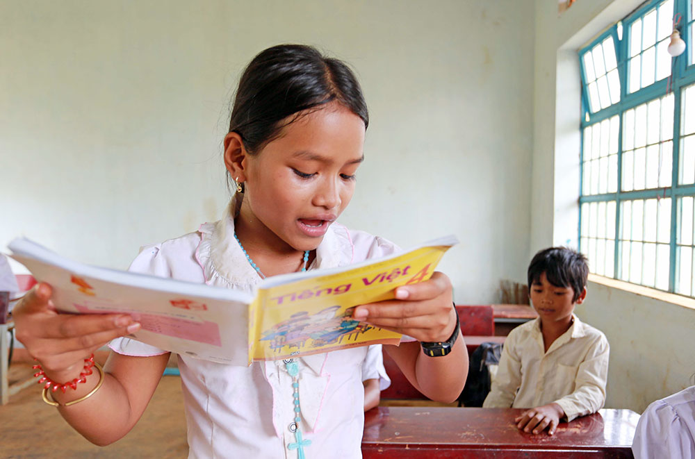 Em Điểu Thị Viên, học sinh lớp 4 (điểm trường thôn 4) đọc bài môn Tiếng Việt trong một buổi học