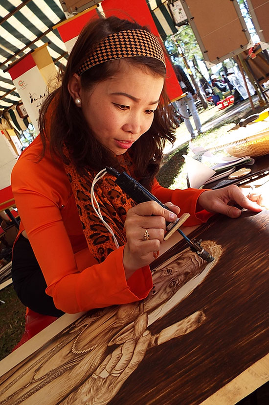 Nghệ nhân Huỳnh Thị Hà đang thực hiện một bức tranh bút lửa về con người Tây Nguyên
