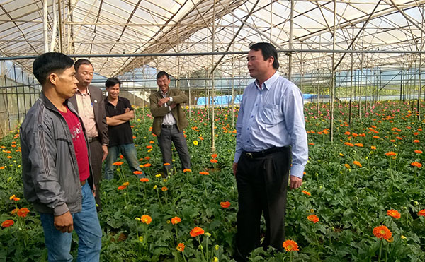 Phó Chủ tịch UBND tỉnh Phạm S (bìa phải) thăm mô hình trồng hoa giúp gia đình anh Phạm Ngọc Phương vươn lên làm giàu