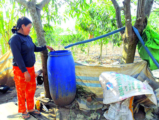 Nước sông được người dân Tân Phú bơm lên, lắng tạm vào thùng trước khi dùng để tắm, giặt